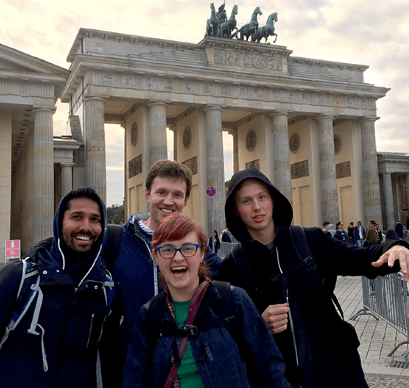 Four colleagues visiting the Brandenburg Gate in Berlin.